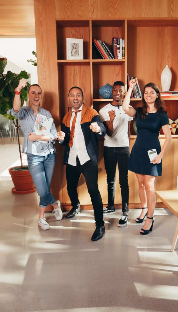 pexels photo 6773498 6773498 A group of diverse business colleagues happily celebrating success in a modern office.